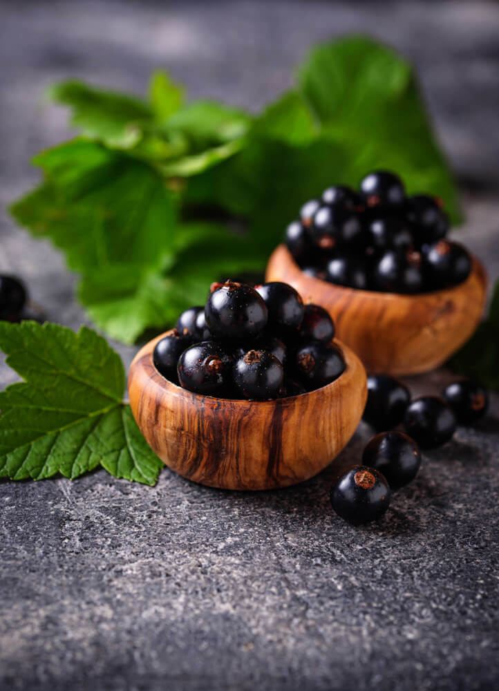 Black,Currant,With,Leaves,In,Wooden,Bowls.,Selective,Focus